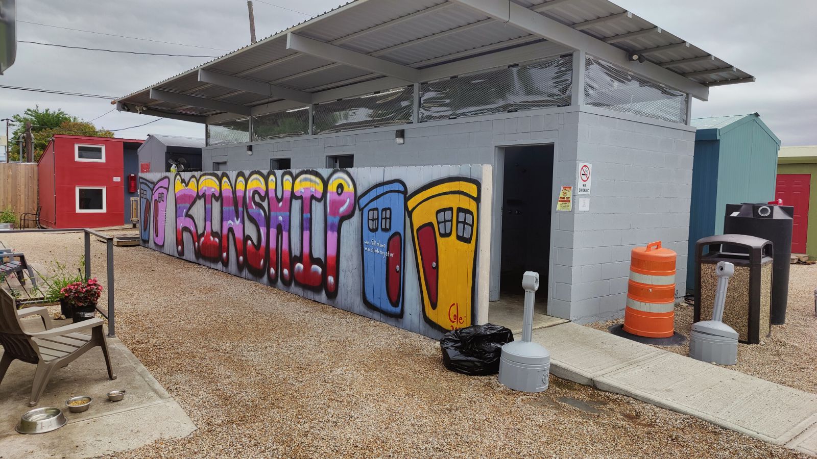 Hygiene facility with a mural on one wall that says "kinship" with painted houses