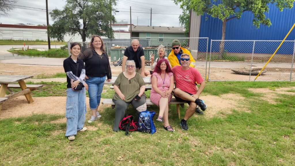 Group that toured Esperanza, including the authors, sitting at a picnic table smiling at the camera